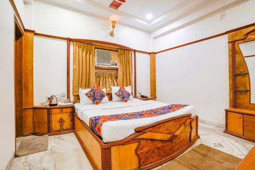 a bedroom with a bed in a room with a window at FabHotel Rest & Peace in Ahmedabad