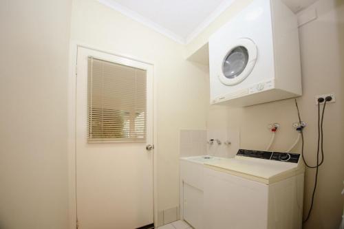 una piccola cucina bianca con forno a microonde e lavandino di Silver Birches Holiday Village - Unit 9 a Bright