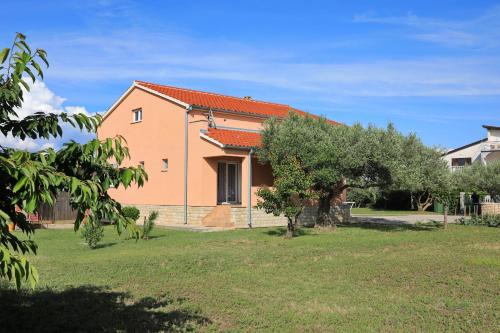 una casa con un albero in un cortile di Holiday home Maslina a Nin