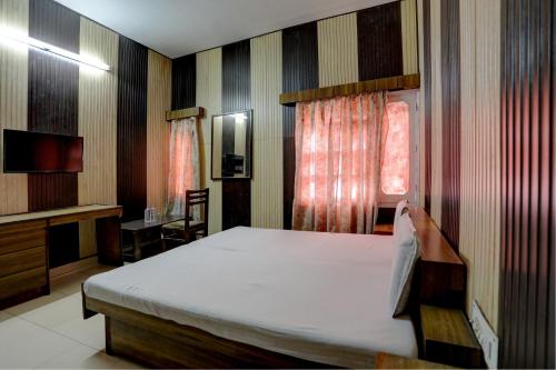 a bedroom with a bed and a desk and a television at OYO Hotel Friday's in Bathinda