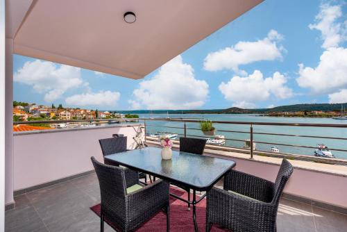 a balcony with a table and chairs and a view of the water at KAIROS in Bilice