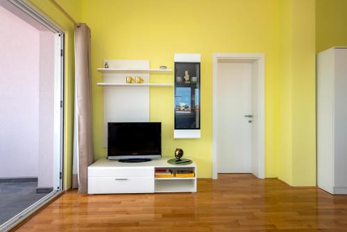 a living room with a tv on a white cabinet at KAIROS in Bilice