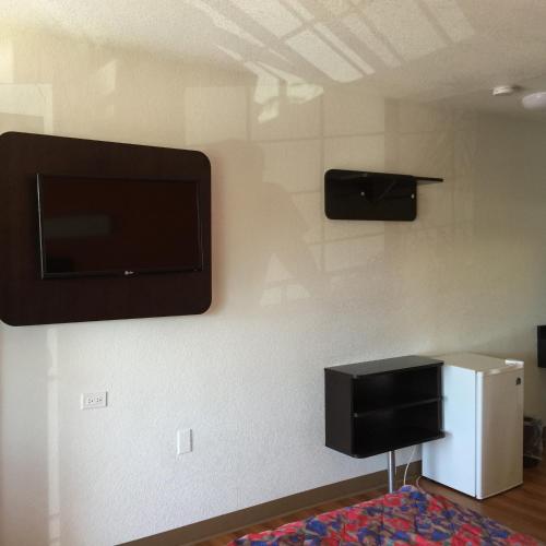 a room with a flat screen tv on the wall at Motel 6 Bakersfield in Bakersfield