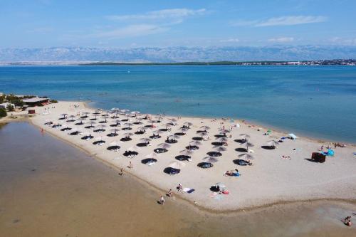 una vista aerea di una spiaggia con ombrelloni di Holiday home Maslina a Nin