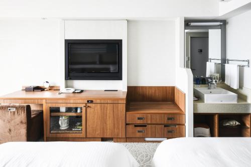 a bedroom with a television and a sink at Vessel Hotel Campana Okinawa in Chatan