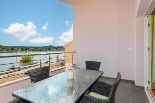 a table and chairs on a balcony with a view of the water at KAIROS in Bilice