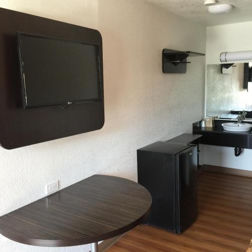 a room with a flat screen tv on a wall at Motel 6 Bakersfield in Bakersfield