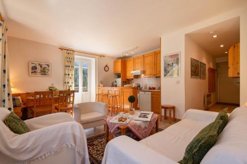 ein Wohnzimmer mit weißen Möbeln und eine Küche in der Unterkunft Résidence Bel'Alp 16 - Happy Rentals in Chamonix-Mont-Blanc
