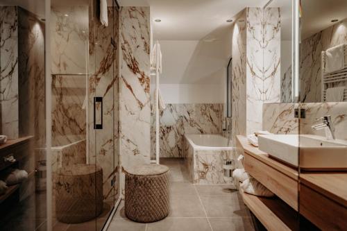 a bathroom with a sink and a tub at Der Eisvogel - Wellness- & Genusshotel in Bad Gögging