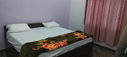 a bed with a blanket on it next to a window at Limewood homestay in Almora
