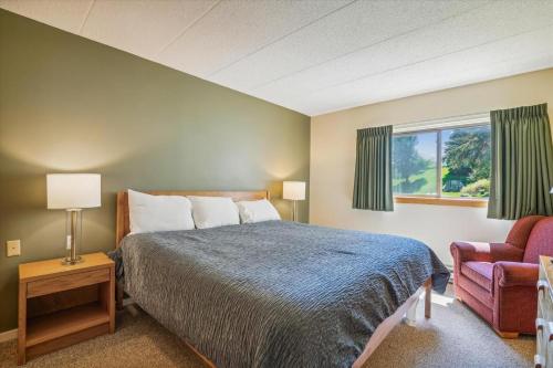 a bedroom with a bed and a chair and a window at Pinnacle B04 in Killington