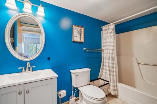a blue bathroom with a toilet and a sink at Pinnacle E17 in Killington