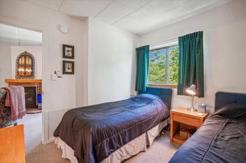 a bedroom with two beds and a table and a window at Pinnacle E17 in Killington