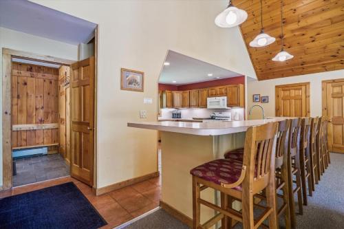 a kitchen with a bar with chairs and a counter top at Sunburst in Killington