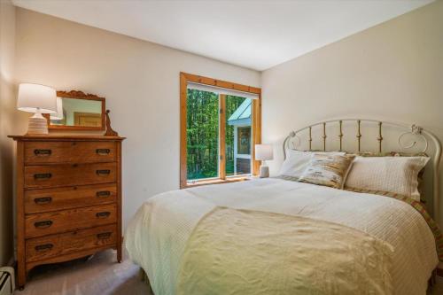 a bedroom with a bed and a dresser and a window at Sunburst in Killington