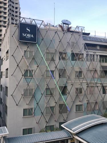 a building with a sign on the side of it at Sora Hotel Silom in Bangkok