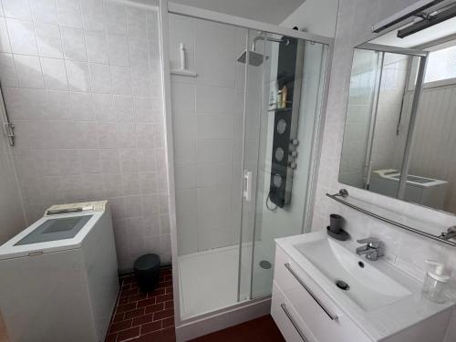 une salle de bain blanche avec un lavabo et une douche dans l'établissement L ECHAPPEE MER Grand 2 pièces centre 500m plage Garage Wifi Fibre PS5 Tout équipé, à La Grande Motte