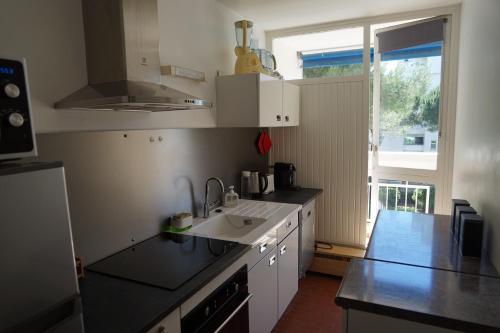 une cuisine avec un évier et un plan de travail dans l'établissement L ECHAPPEE MER Grand 2 pièces centre 500m plage Garage Wifi Fibre PS5 Tout équipé, à La Grande Motte