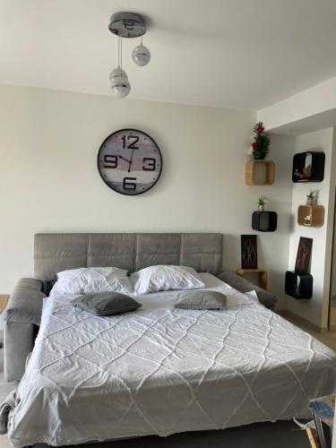 a bedroom with a large bed with a clock on the wall at Forum in Antibes