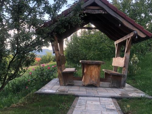 une structure en bois avec un banc et une table dans l'établissement Cabana Dintre Fagi, à Poiana Mărului