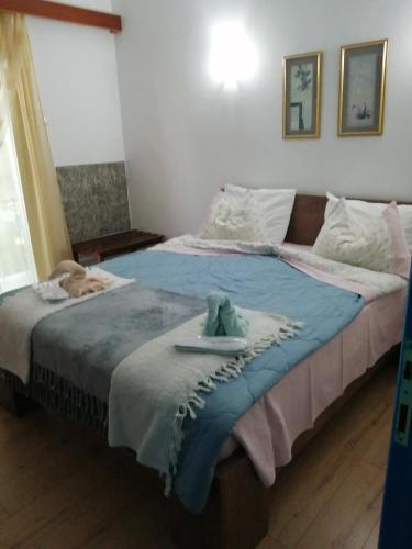 a bedroom with a large bed with a stuffed animal on it at Hotel Fotini in Kamena Vourla