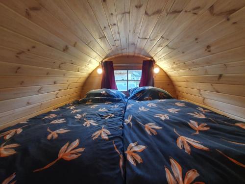 a bedroom with a bed in a log cabin at Clamping Schlaffässer im Ferienpark Wolfsschlucht Prüm Eifel in Prüm