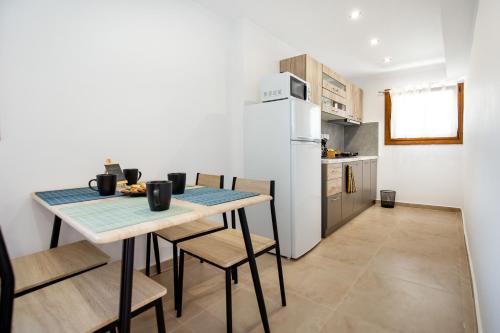 a kitchen with a table with chairs and a refrigerator at Maison Centrale in Limenaria