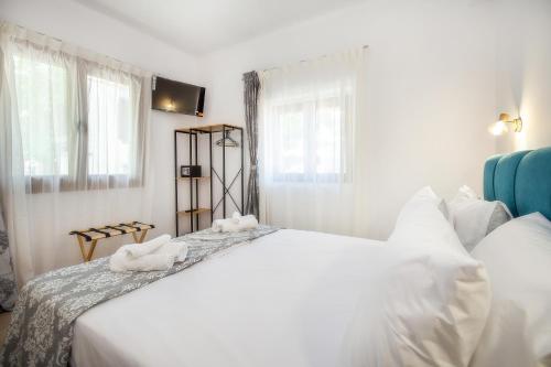 a bedroom with a large white bed with towels on it at Maison Centrale in Limenaria