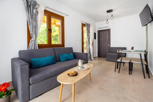 a living room with a blue couch and a table at Maison Centrale in Limenaria