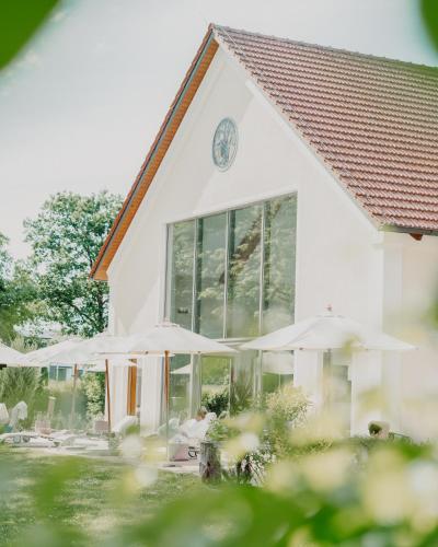 a white building with umbrellas in front of it at Der Eisvogel - Wellness- & Genusshotel in Bad Gögging