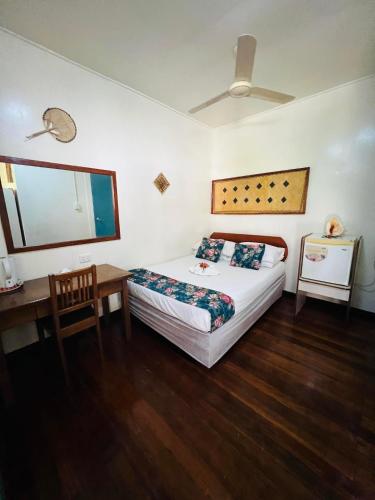 a bedroom with a bed and a table and a desk at Qua Roviana Accommodation in Munda