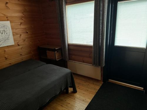 1 dormitorio con 1 cama, 2 ventanas y puerta en Himos, Areenan alue, en Jämsä
