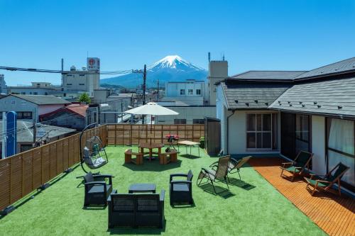 a balcony with chairs and a table and a mountain at FUJIクロスゲートハウス in Fujiyoshida
