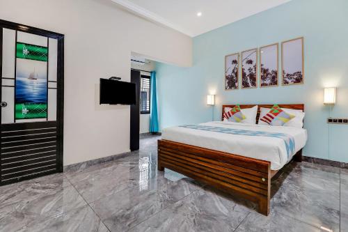 Schlafzimmer mit einem Bett und einem Flachbild-TV in der Unterkunft OYO Home Royal Salem in Kakkayam