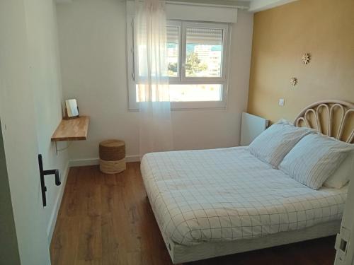 une petite chambre avec un lit et une fenêtre dans l'établissement Lumineux et cosy F3 vue mer, à Ajaccio