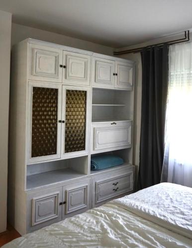 a white cabinet in a bedroom with a bed at Barbara in Gospić