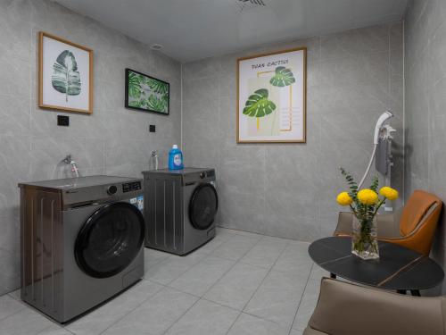 a laundry room with a washing machine and a table at Campanile Shenzhen Guanlan Golf in Shenzhen