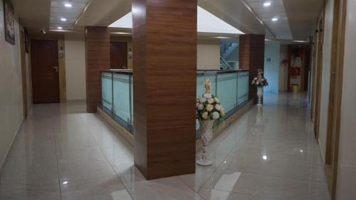 a hallway with columns in a building with flowers at Clarks Collection Somnath in Somnath