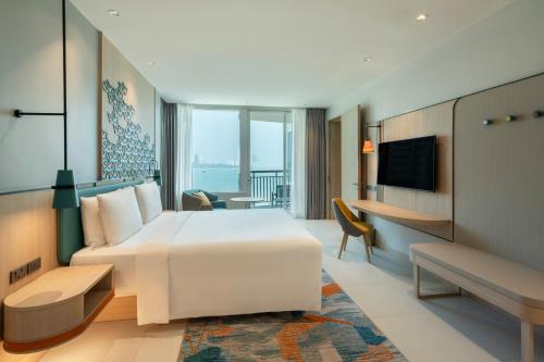 a hotel room with a bed and a television at Holiday Inn Pattaya by IHG in Pattaya Central