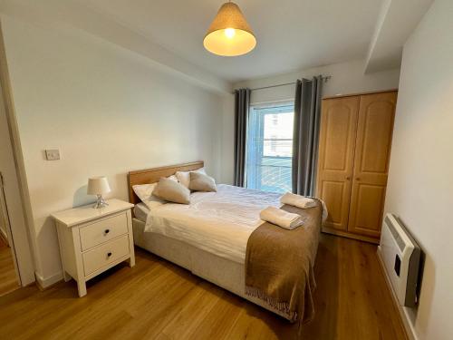 una camera con un letto, un comodino e una finestra di Bridge View Apartment a Waterford