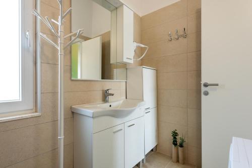 uma casa de banho com um lavatório e um espelho em KAIROS em Bilice