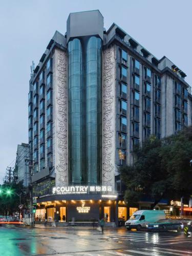 a building on a street with cars in front of it at Country Inn & Suite by Radisson, Nanchang Tengwangge Wanshou Palace Subway Station in Nanchang