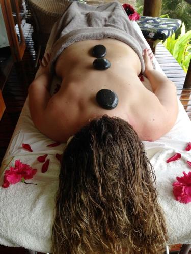 a man laying on a towel with three rocks on his back at Naveria Heights Lodge in Savusavu
