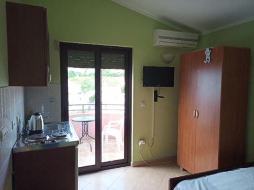 a kitchen with a door leading to a patio at Apartments Normannia in Dobra Voda