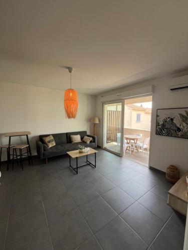 un salon avec un canapé et une table dans l'établissement T2 entre mer et montagne, à Santa-Lucia-di-Moriani