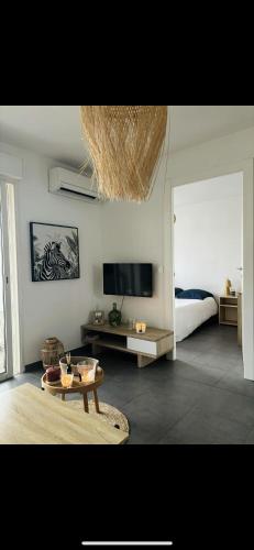 - un salon avec un lit, une table et une télévision dans l'établissement T2 entre mer et montagne, à Santa-Lucia-di-Moriani