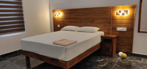 a bedroom with a large bed with a wooden headboard at Bella Casa in Vagamon