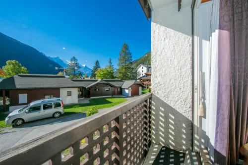 a view from the balcony of a house with a car parked at Residence de Lognan- Les Jorasses 26 - Happy Rentals in Chamonix-Mont-Blanc