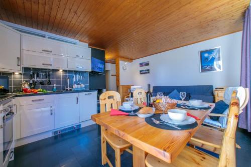 une cuisine et une salle à manger avec une table en bois dans l'établissement Residence de Lognan- Les Jorasses 26 - Happy Rentals, à Chamonix-Mont-Blanc