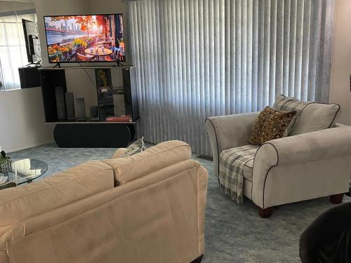 sala de estar con 2 sofás y TV de pantalla plana en Stays by HOC - Pet Friendly Cozy & Comfort Cape, en Willingboro